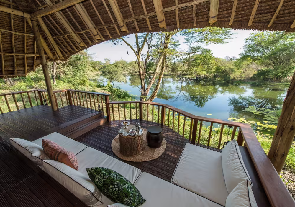 Luxury tented suite with an outdoor deck overlooking natural springs at Finch Hattons, Tsavo West National Park